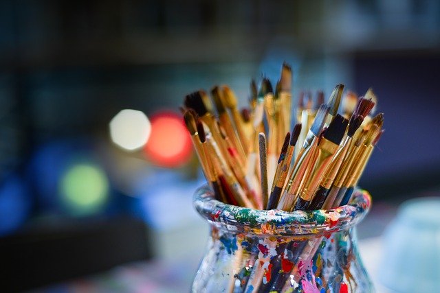 Art brushes in a colored bowl.