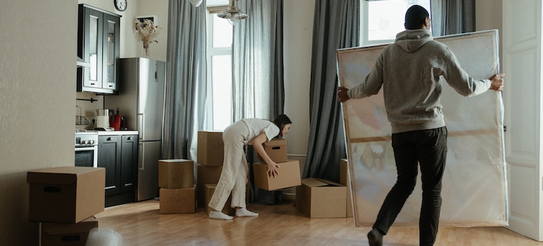 two people organizing moving boxes in an apartment 